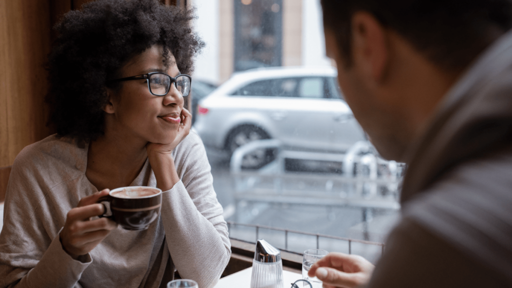 Woman drinking coffee in cafe.png